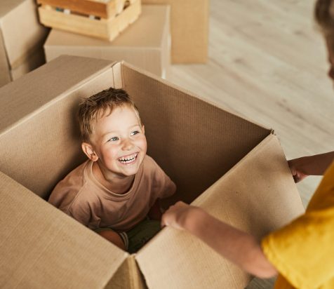 Kid Playing in Cardboard Box